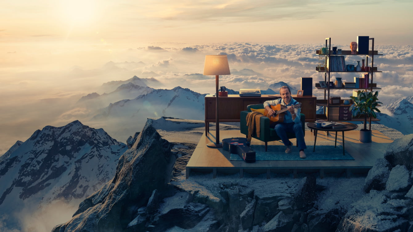 Image of man on mountain top playing guitar